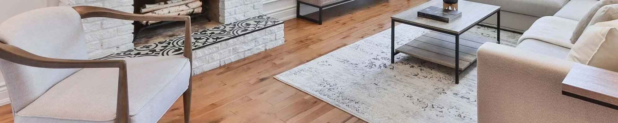 Hardwood floors in a stylish living room with a fireplace and area rug
