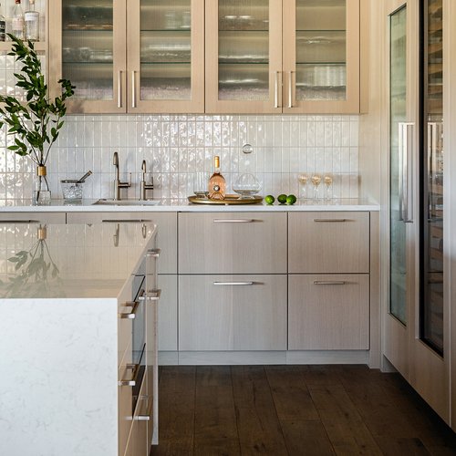 Luxury kitchen in Holland, MI with light wood cabinets and a white tile backsplash by Michigan Tile Inc