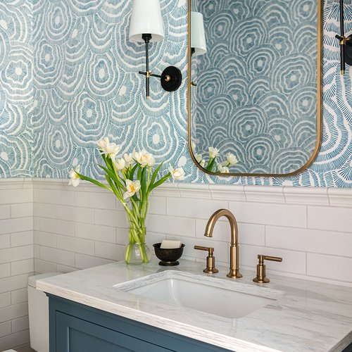 Modern bathroom with blue accents and white countertops by Michigan Tile Inc